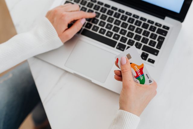 a%20person%20holding%20their%20credit%20card%20and%20using%20their%20laptop a%20person%20holding%20their%20credit%20card%20and%20using%20their%20laptop